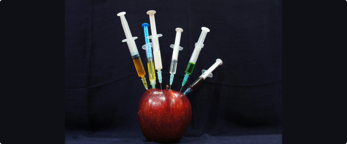 Apple with syringes in it